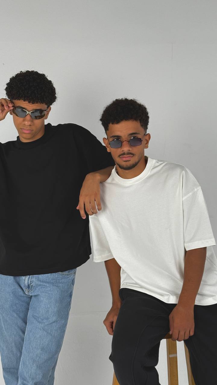 Two men wearing sunglasses against a plain background