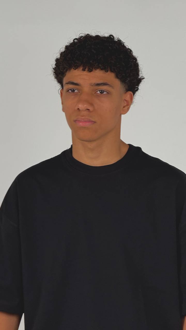 Person wearing a black shirt against a plain background